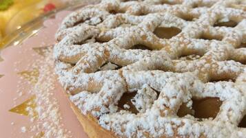 A dessert plate with a powdered pastry and a background of other desserts.