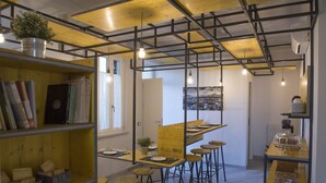A modern kitchen with wooden shelves, a bar area, and stools. - L'Officina di Apollo (Palermo)