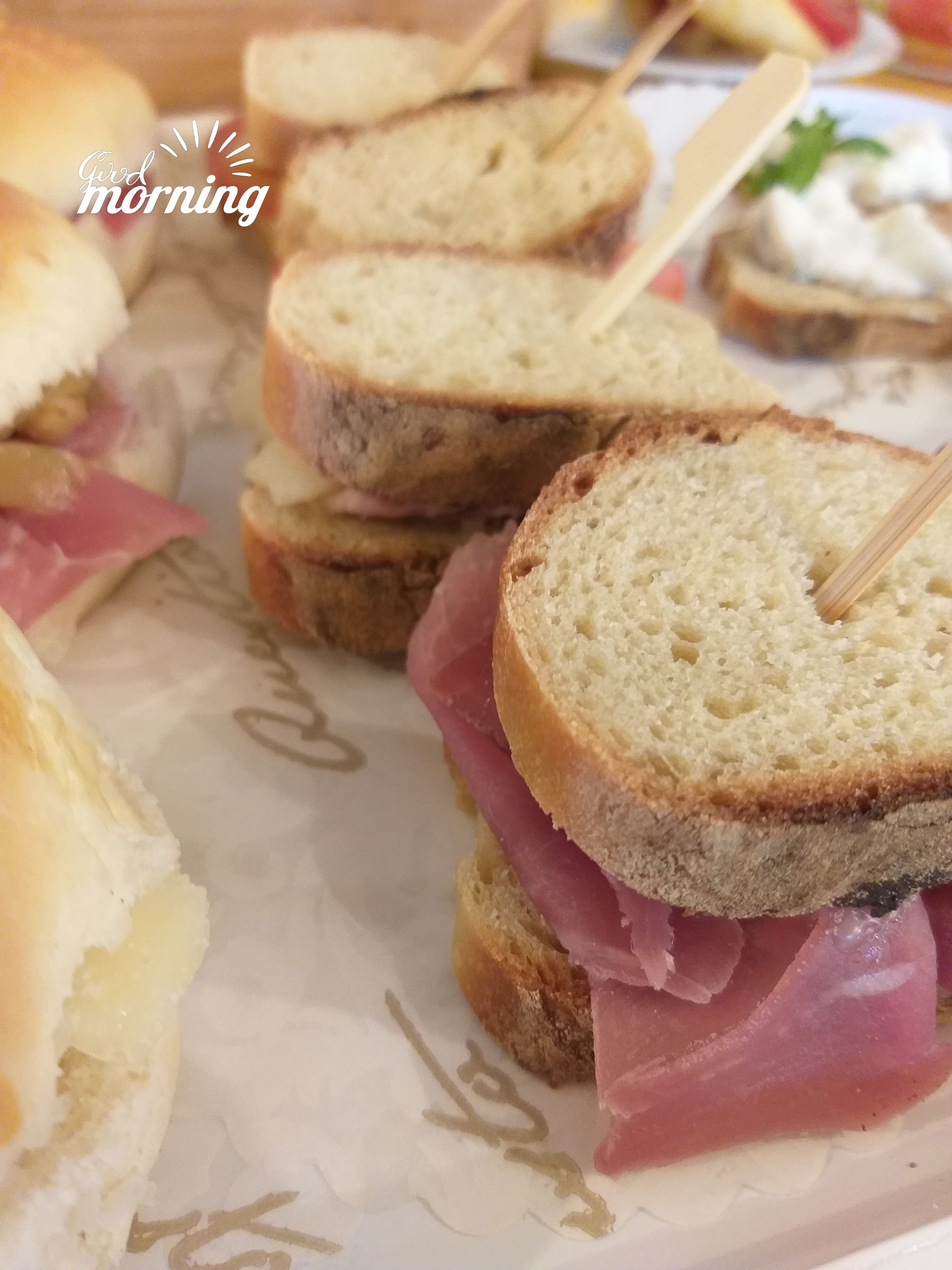 A close-up of a sandwich with ham and cheese on a slice of bread.