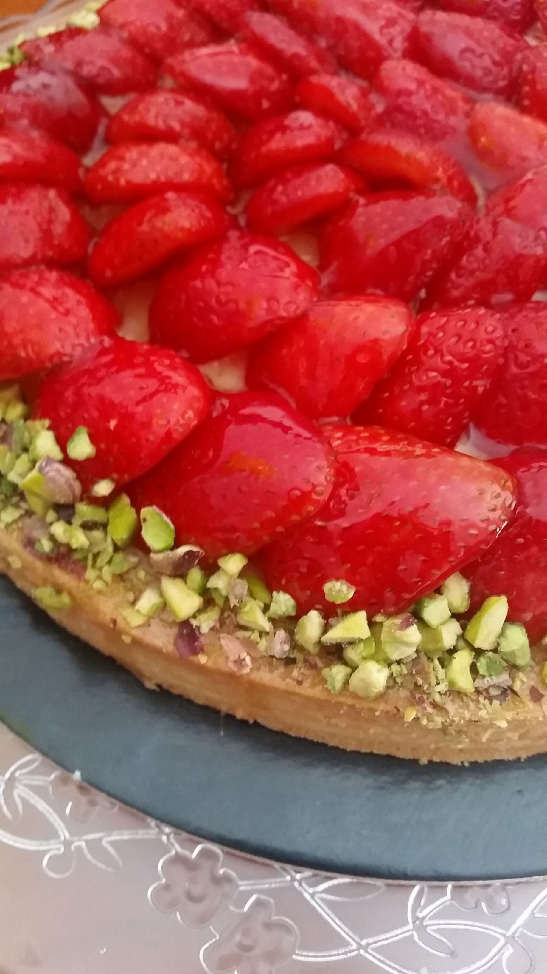 A dessert with strawberries and chopped nuts.