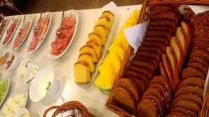 A buffet table with various food items including bread, pastries, and dips.