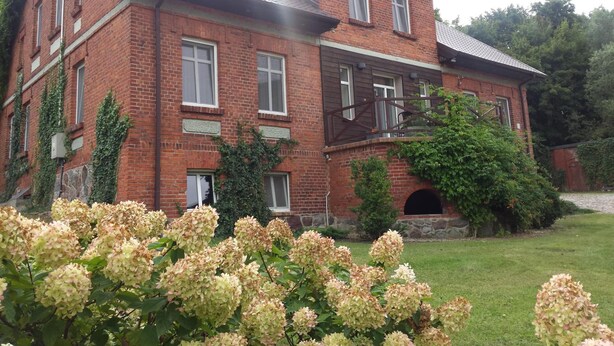 A large brick building with multiple windows and a prominent entrance.