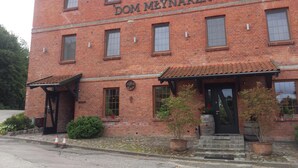 A two-story brick building with the name 'DOM MEYNARZA' on the facade.