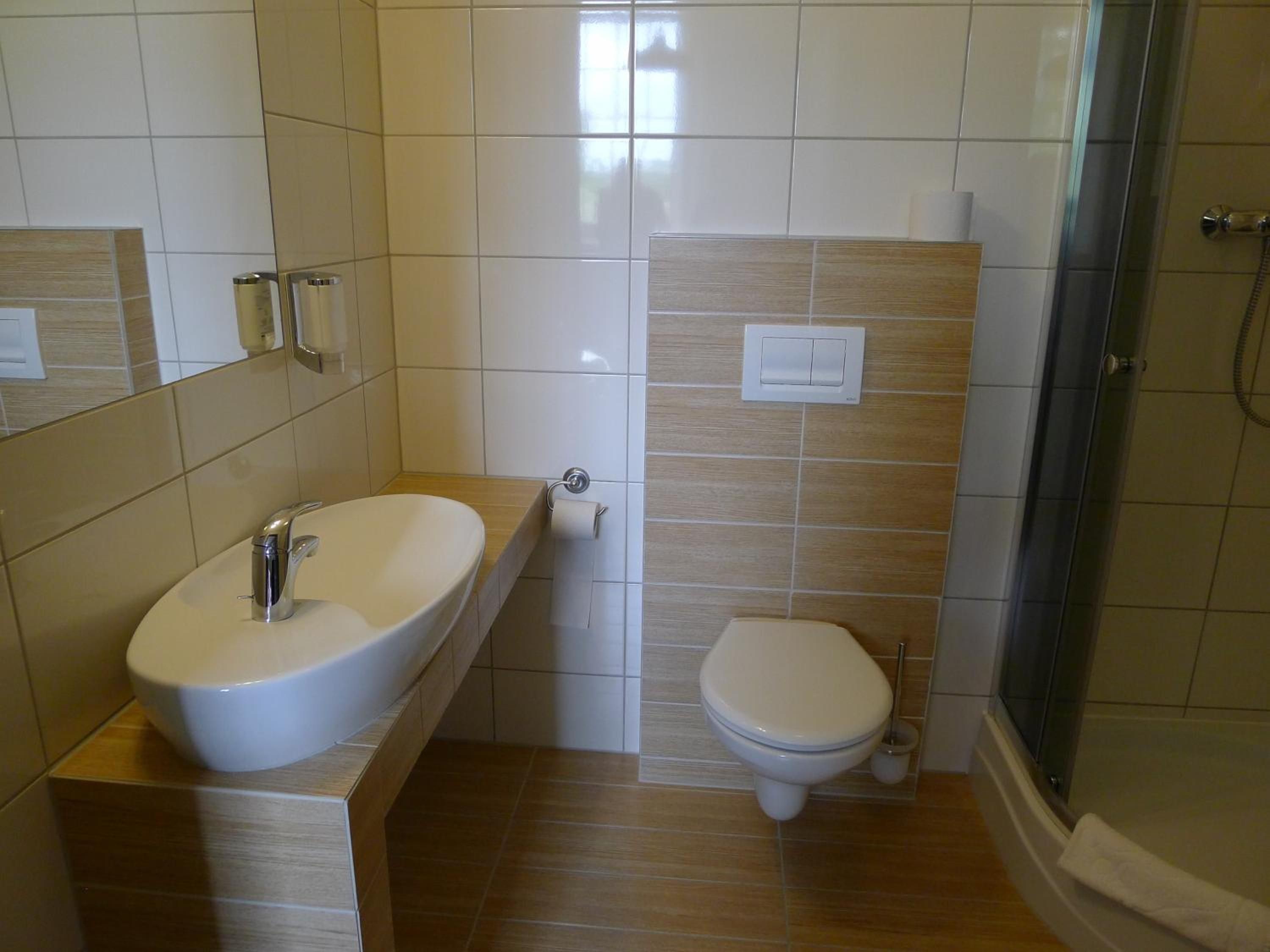 A bathroom with a sink, toilet, and shower.
