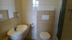 A bathroom with a sink, toilet, and shower.