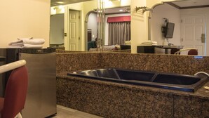 Eine Küche mit Granit-Arbeitsplatten, einem Edelstahl-Kühlschrank und einer Spüle.