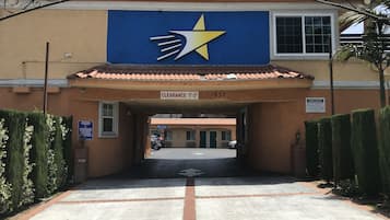 Entrada de un edificio con un letrero azul que muestra una estrella y una flecha, un cartel de espacio libre y el número 1830.