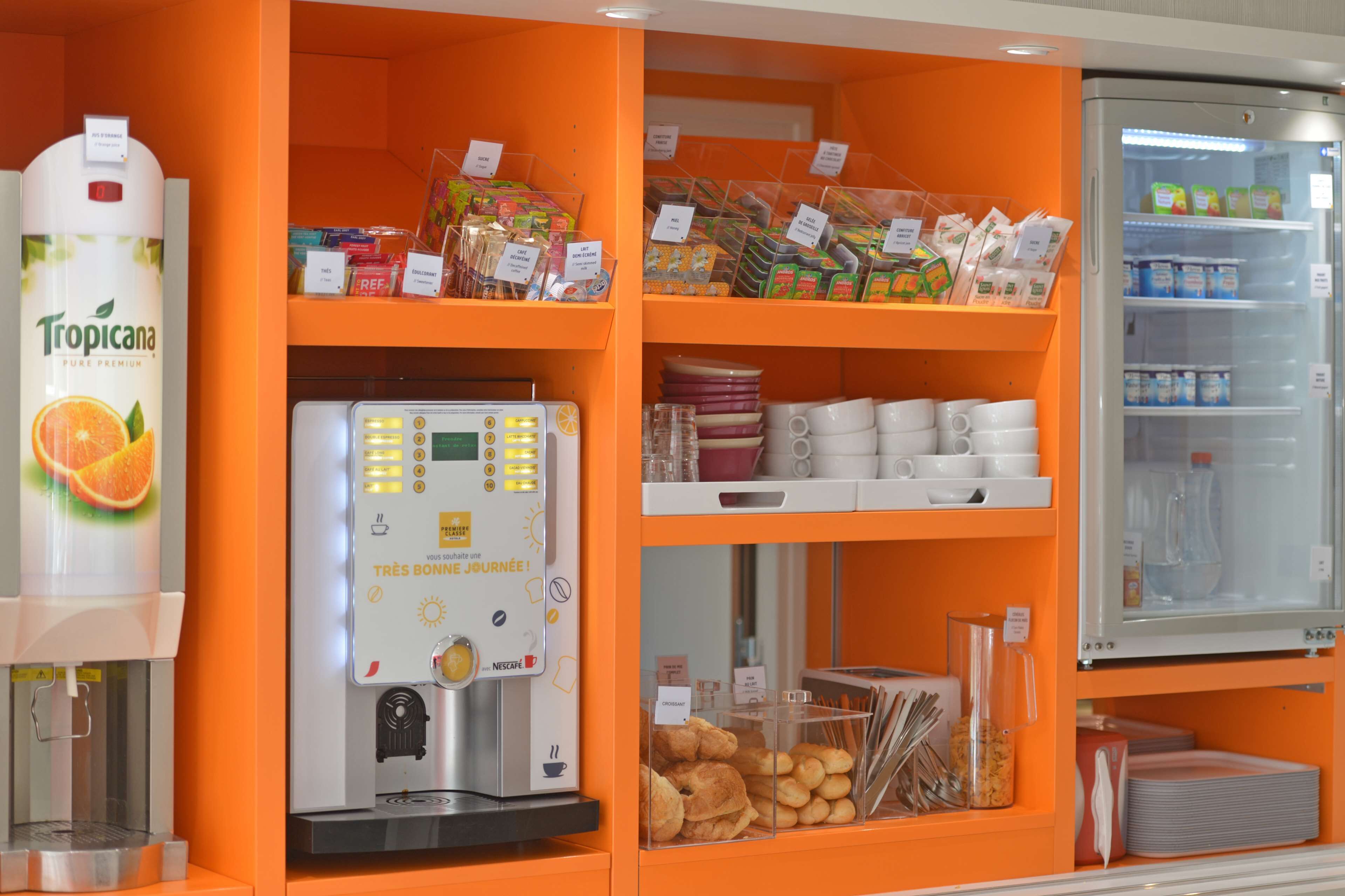 Eine Selbstbedienungs-Kaffeestation mit Kaffeeautomat, gekühlten Regalen und Vorräten an Snacks und Beilagen.