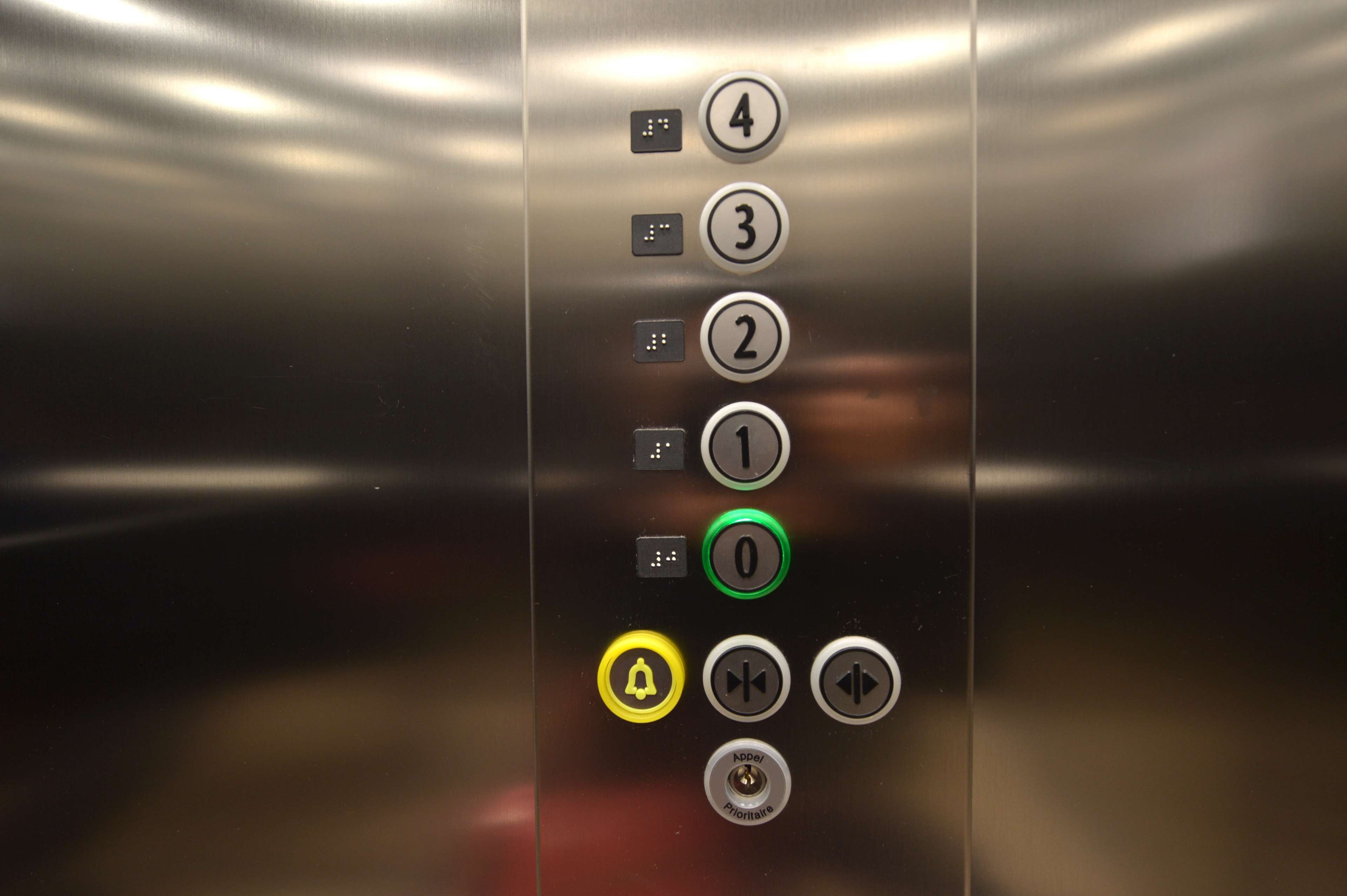 An elevator control panel with buttons for floor selection and emergency features.