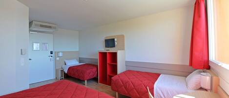 A hotel room with two beds, a TV, a wardrobe, and a desk.