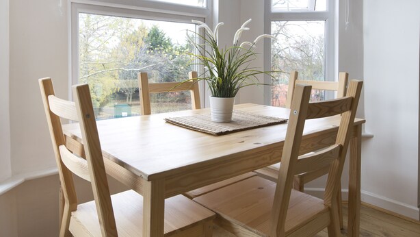 A wooden dining table with four chairs, a potted plant, and a woven placemat. - Sleep & Stay Oxford - Beautiful Flat Close to town (Oxford)