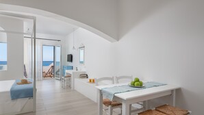A bright, open room with a white table, chairs, and a view of the sea. - Stegna Akti (Rhodes)