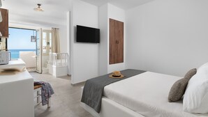 A modern hotel room with a bed, a TV, a wooden wardrobe, and a view of the sea. - Stegna Akti (Rhodes)