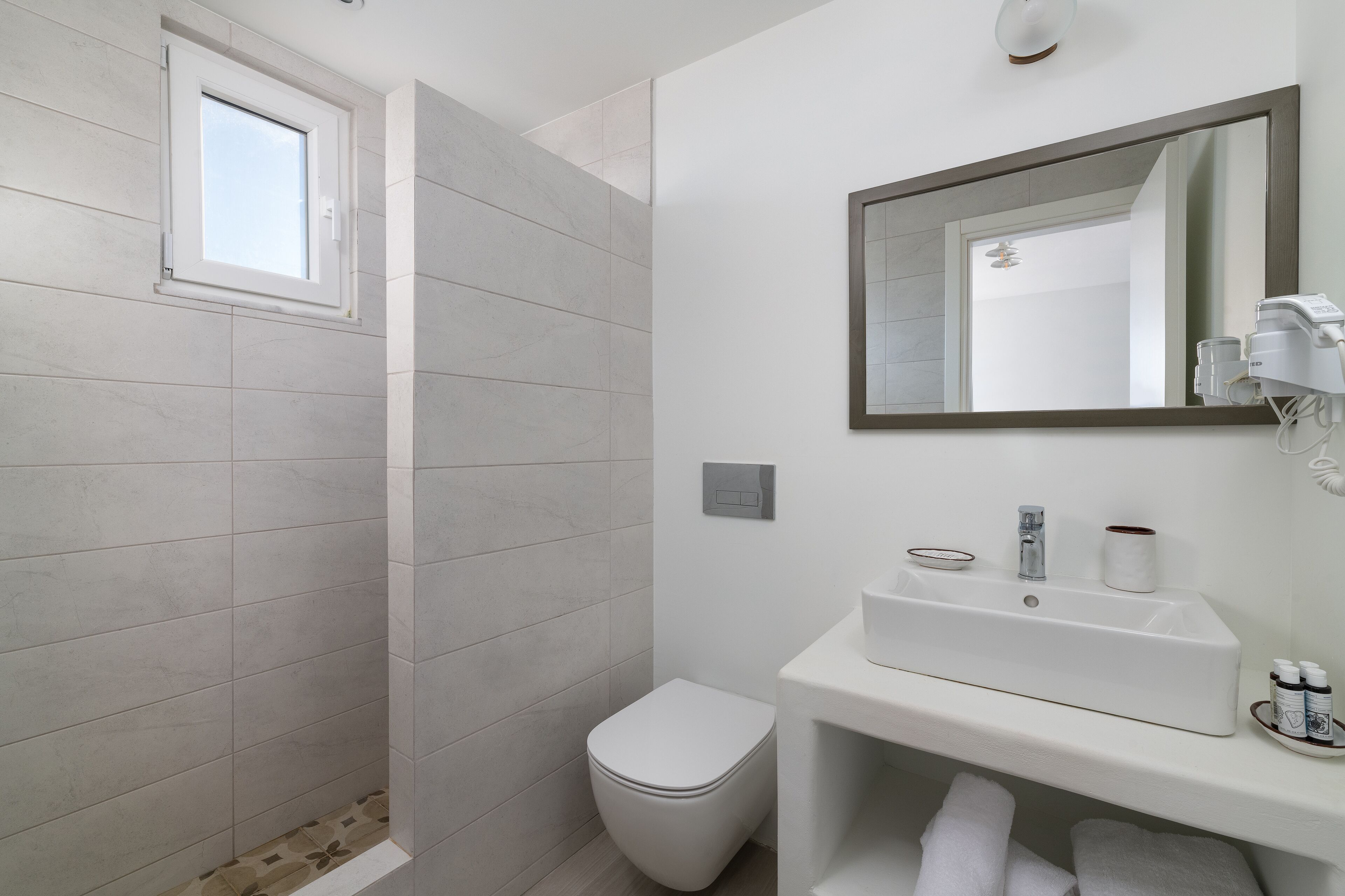 A modern bathroom with a shower, toilet, and sink.