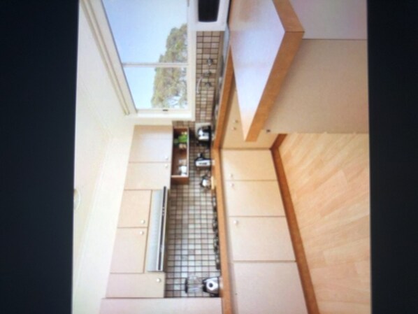 Kitchen features a window and wooden cabinets with a tiled backsplash.