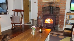 Ein gemütliches Wohnzimmer mit Kamin, Holzmöbeln und einer Bücherwand.