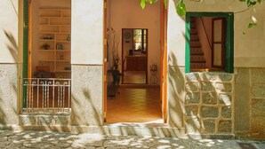 A building with a stone facade, a wooden staircase, and a balcony with green shutters. - Casa Fortuny in Soller (Sóller)