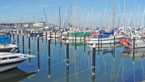 Een jachthaven met veel boten in de haven, rustig water en heldere lucht.