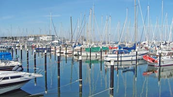 Una marina con numerose imbarcazioni ormeggiate, acqua calma e cielo sereno.
