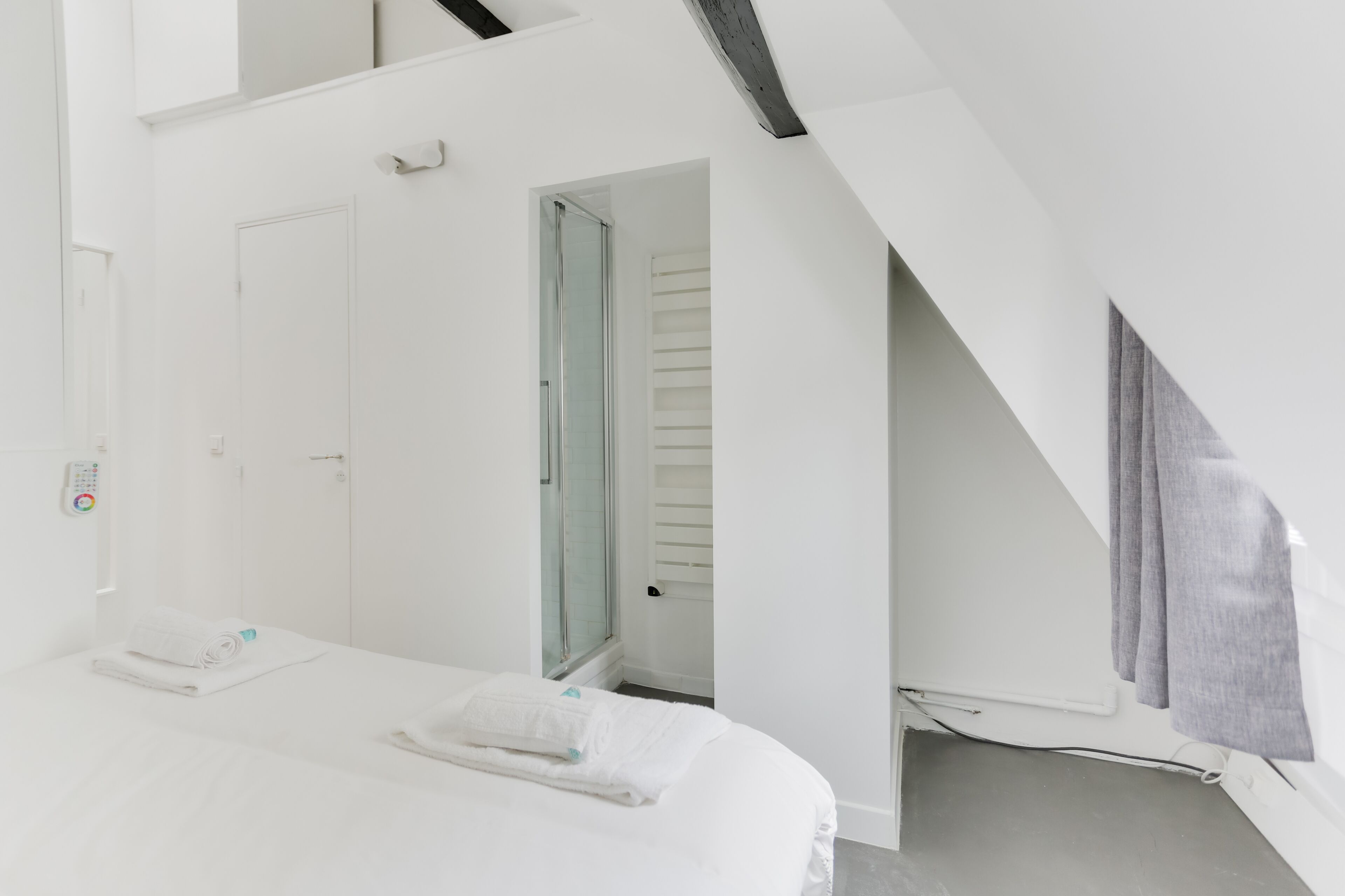 Quarto moderno e claro, com uma cama, uma porta e uma janela.