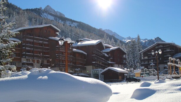 A snow-covered mountain resort with wooden buildings, a clear sky, and a bright sun. - 2-Room + Cabin Apartment for 4-6 in Heart of Station - WiFi & Balcony (Valfréjus)