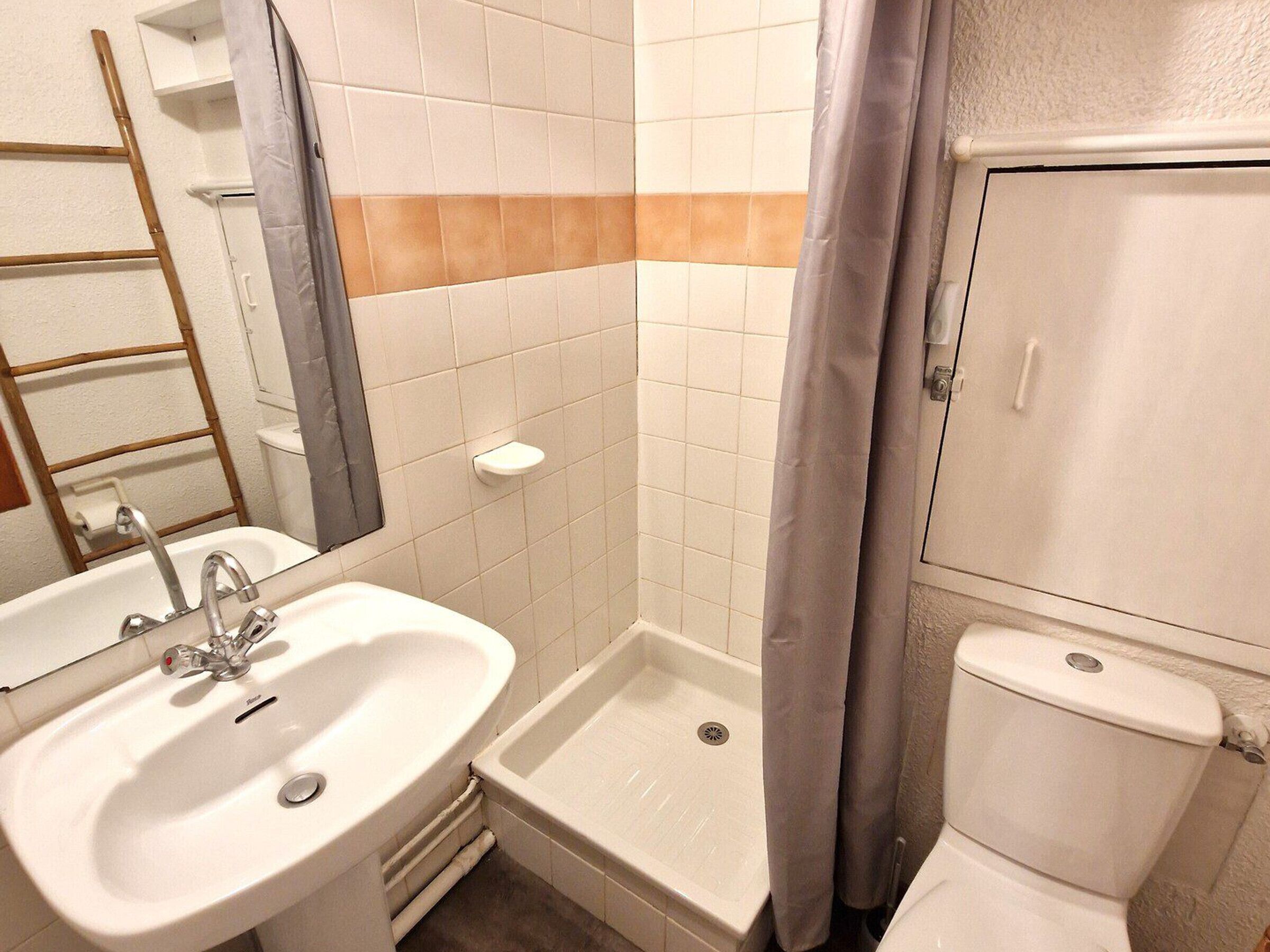 Une salle de bain avec un lavabo, une douche et des toilettes.