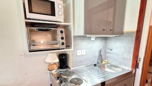 A compact kitchenette with a microwave, toaster, and small refrigerator. - Renovated studio for 2-3 in Valfréjus, balcony and slope view (Valfréjus)