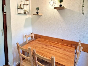 A dining area with a table and six chairs, surrounded by simple, functional decor.