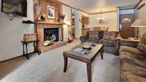 A living room with a fireplace, a sofa set, a coffee table, and a TV mounted on the wall. - Main Street/Town Lift, Pool, Hot Tubs, Location, Comfort, Value, A/C, Fireplace (Park City)