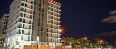 Un hotel de varios pisos con un diseño moderno, que destaca un cartel grande de Hilton Garden Inn.