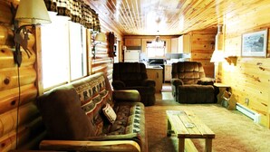 A cozy cabin interior with a sofa, armchairs, a dining table, and a kitchen area. - Peace, Privacy and a Pontoon!! No steps in home or to water! (Eagle River)