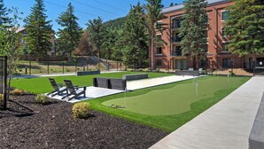 A landscaped area with a putting green, seating, and a building with multiple floors and balconies. - Main Street/Town Lift, Pool, Hot Tubs, Location, Comfort, Value, A/C, Fireplace (Park City)