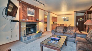 A living room with a fireplace, a television mounted on the wall, and a sofa. - Main Street/Town Lift, Pool, Hot Tubs, Location, Comfort, Value, A/C, Fireplace (Park City)
