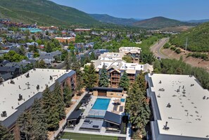 A hotel with a rooftop pool, surrounded by trees and a view of a town. - Main Street/Town Lift Access | Comfort | Value | Pool | Hot Tubs | Wifi | A/C  (Park City)