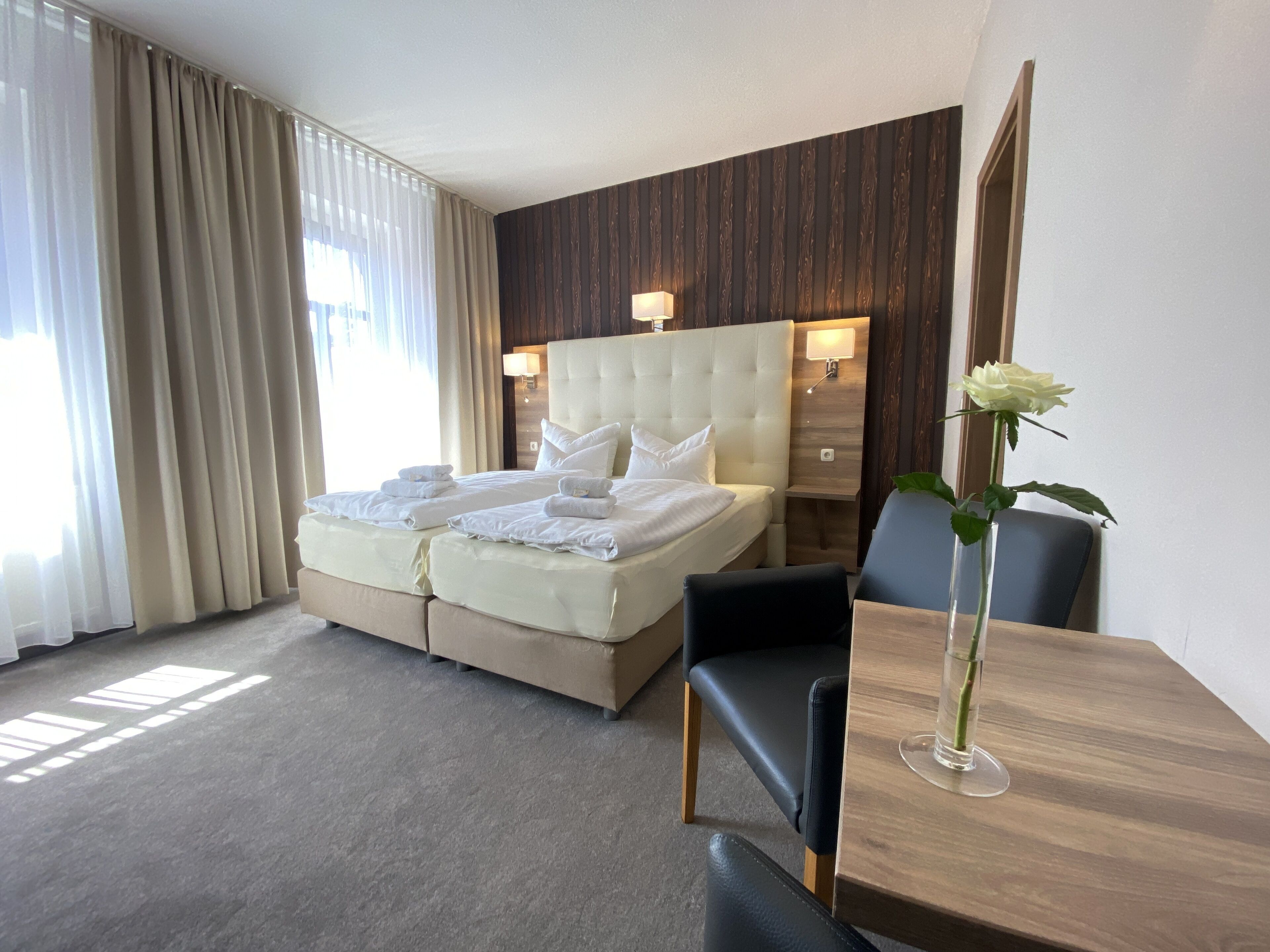 Una habitación de hotel con una cama grande, un escritorio y una silla.