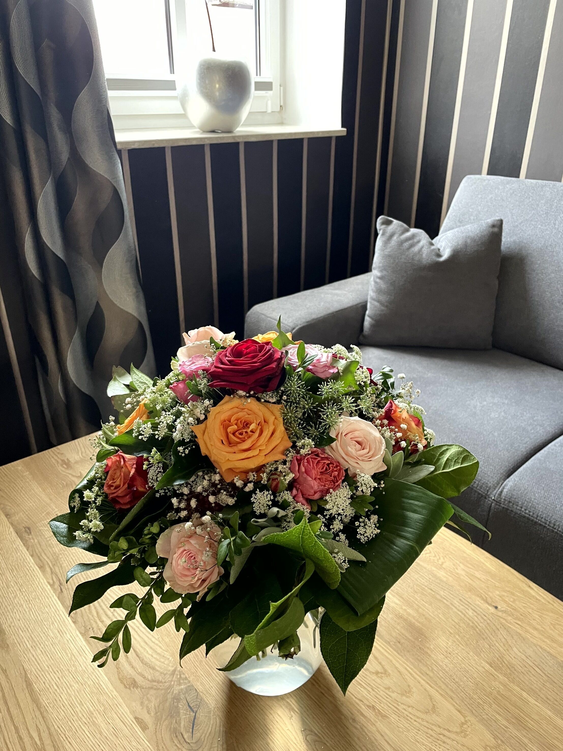 Un bouquet di fiori in un vaso di vetro su un tavolo di legno.