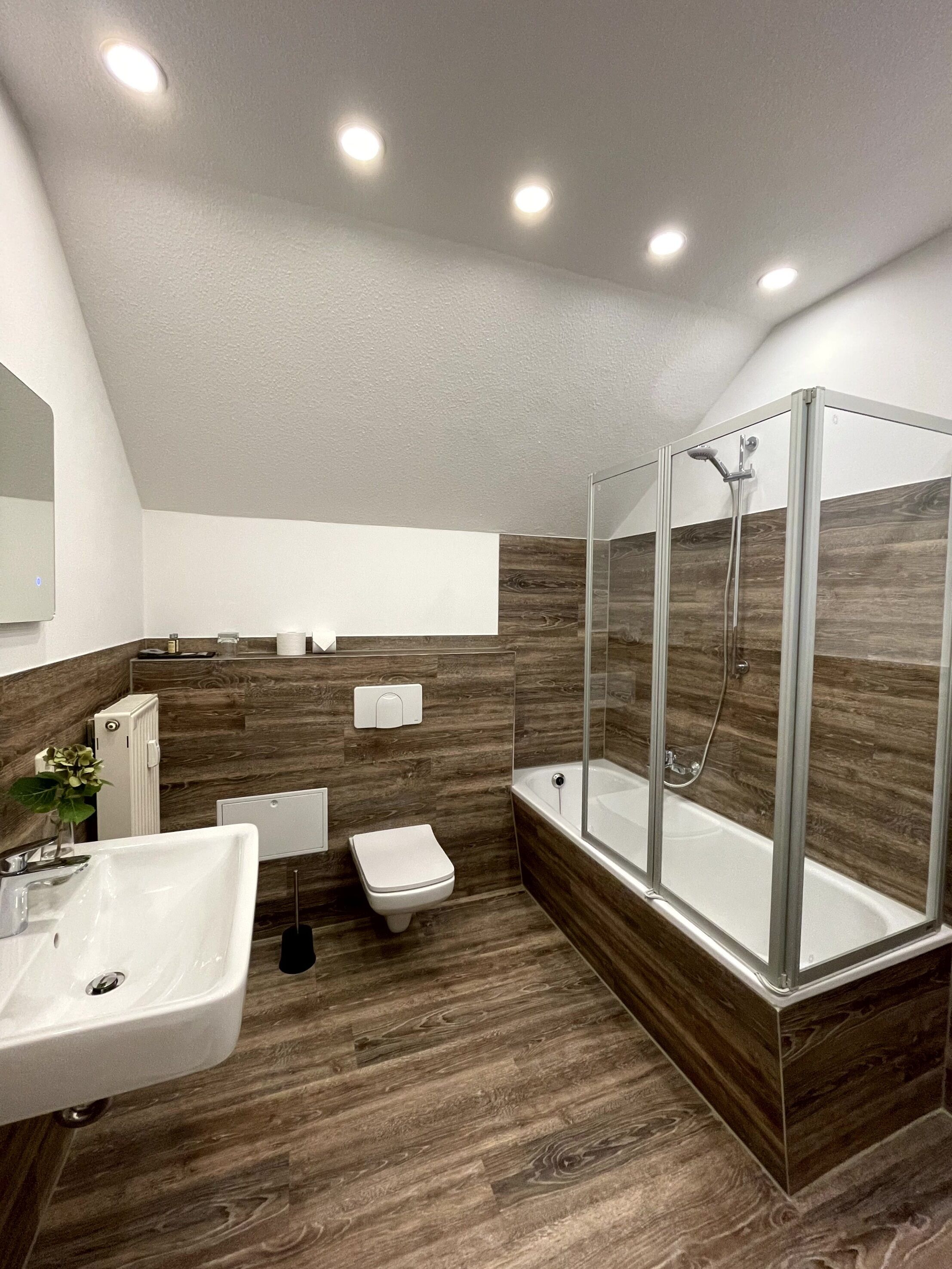 Un baño moderno con ducha, inodoro y lavamanos.
