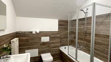 Un baño moderno con ducha, inodoro y lavamanos.