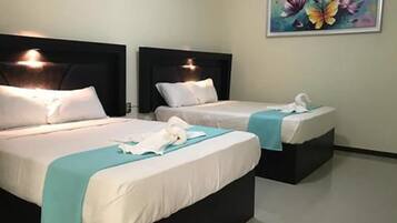Habitación cuádruple estándar, 2 camas Queen size | Escritorio, tabla de planchar con plancha, wifi gratis y ropa de cama