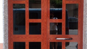 A wooden door with multiple glass panels and a metal handle. - Corso Messina (Crotone)