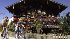 Un edificio tradizionale in legno con tetto spiovente, decorato con ornamenti e fiori.