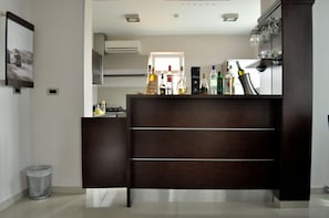 A modern kitchen with a dark wooden cabinet, a window, and various kitchen appliances. - Hotel 018 In Nis (Niš)