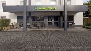 Et bed and breakfast hotel med en moderne facade, udendørs siddepladser og en indbydende indgang.