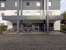 Un hotel B&B con fachada moderna, zona de estar al aire libre y una entrada acogedora.