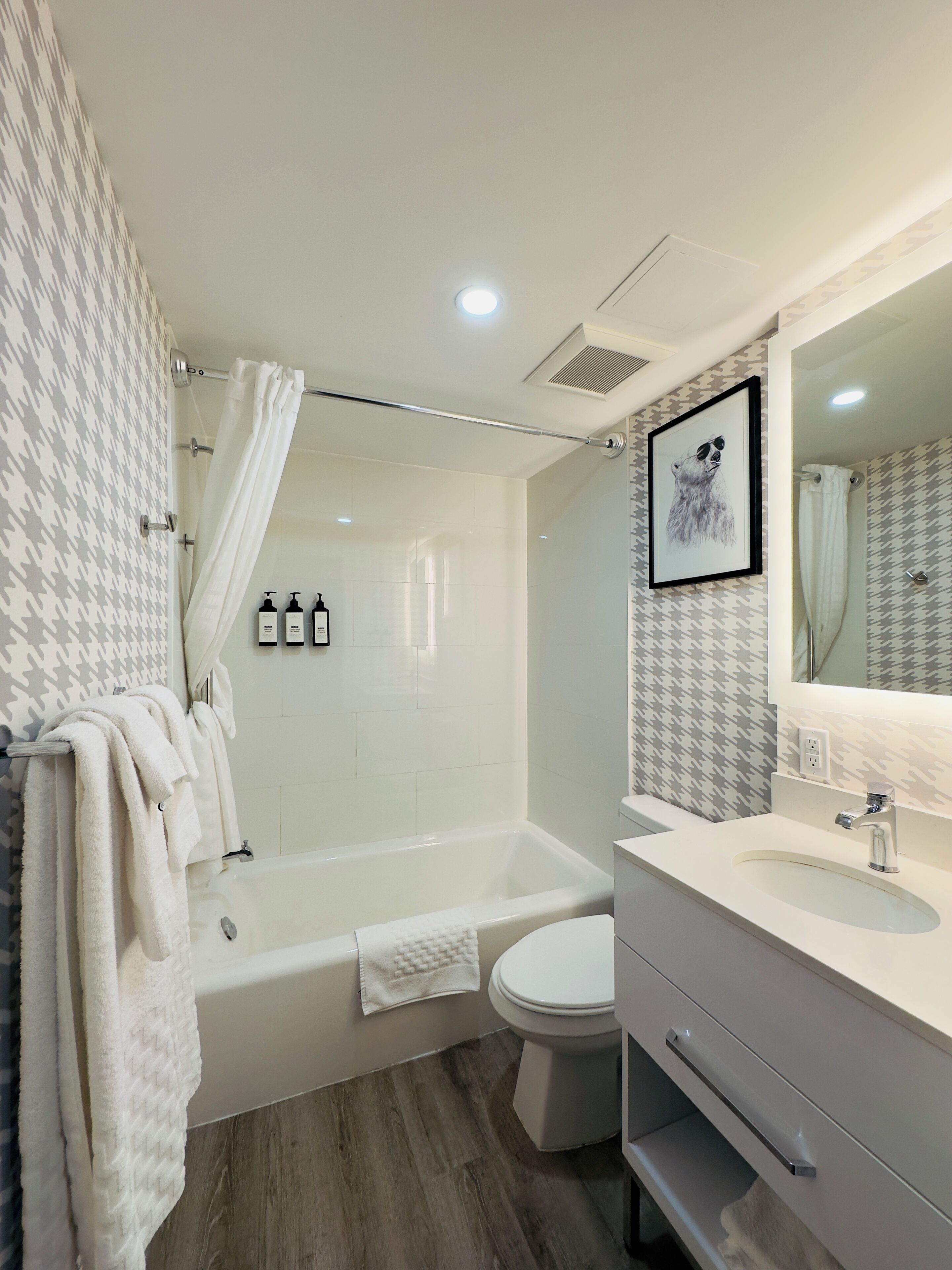 A modern bathroom with a bathtub, toilet, and vanity.