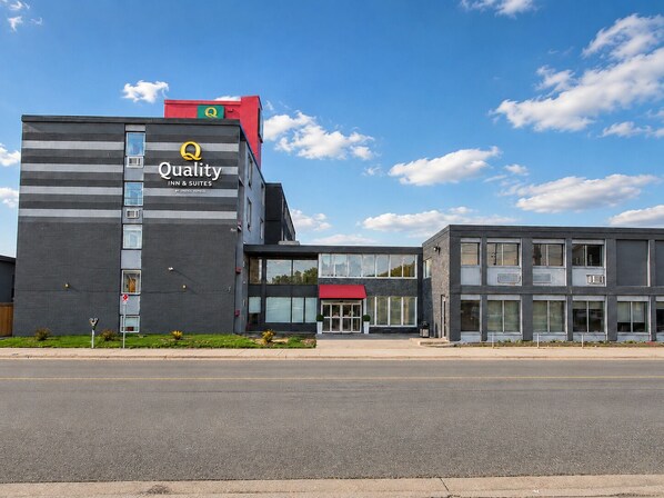 A modern building with a sign for 'Quality Inn & Suites by Choice Hotels.'