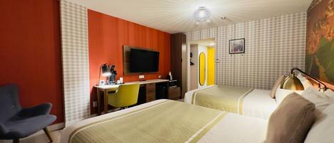 A hotel room with two beds, a desk with a chair, a television, and a mirror.