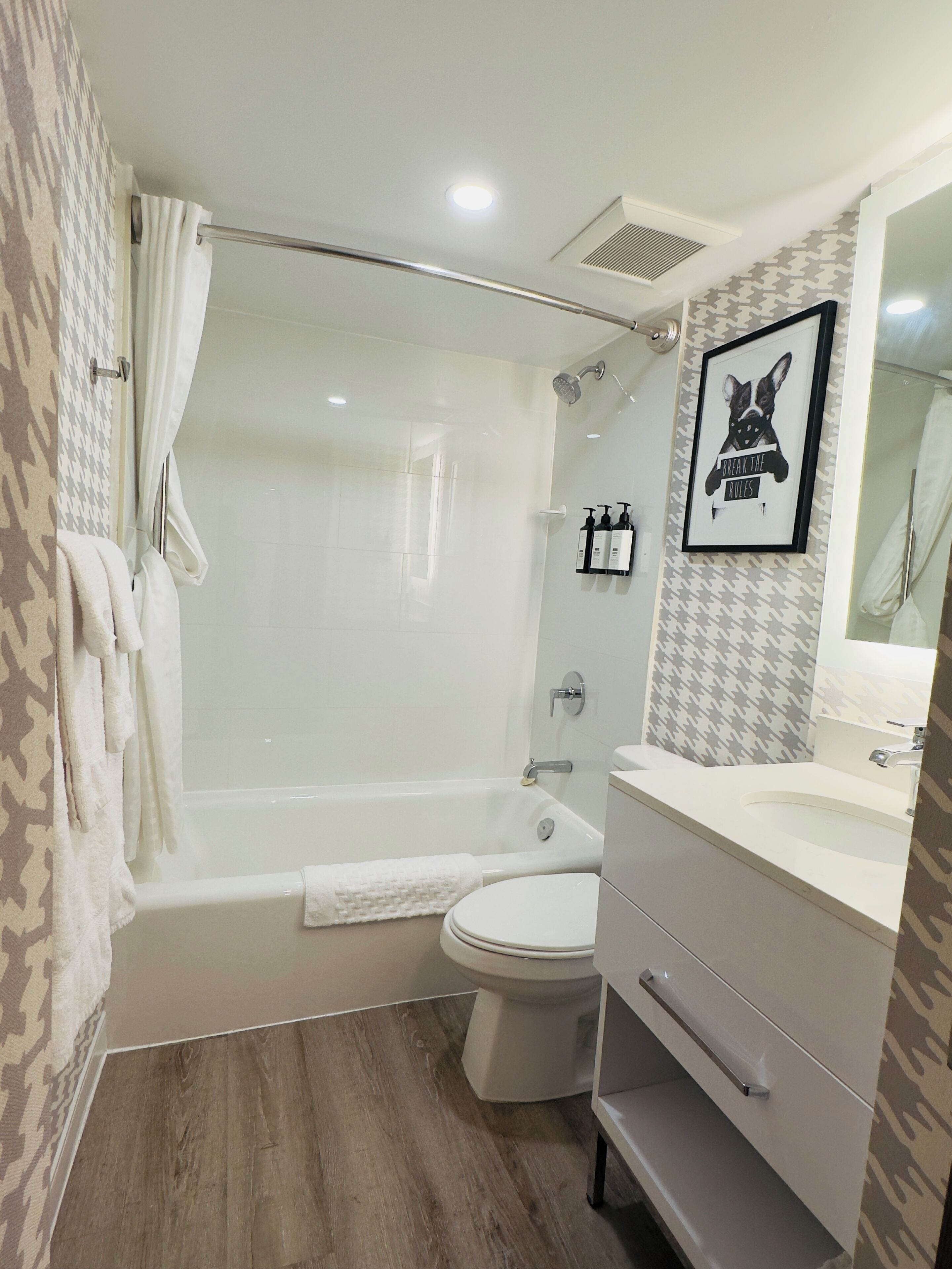 A modern bathroom with a bathtub, toilet, and vanity.