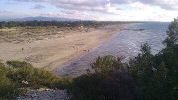 Enjoy a serene beach experience with a wide, open shoreline and scenic views of the surrounding terrain.