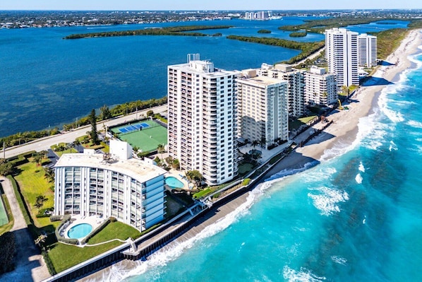 A coastal hotel with multiple high-rise buildings, a beachfront, and a pool area.